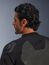 Alpinestars GP Force V2 Leather Jacket, Black, close-up shot from behind, featuring the black star logo on the upper back and GP Lite Evo DFS shoulder protector, multi-panel leather and textile construction, studio view of the rider's profile and gear details.