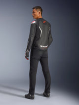 Alpinestars GP Force V2 Leather Jacket, Black and White, rear view showing leather construction with white accents and red logos, worn with black pants and racing gloves, featuring bold Alpinestars branding on the lower back, sport-fit motorcycle gear