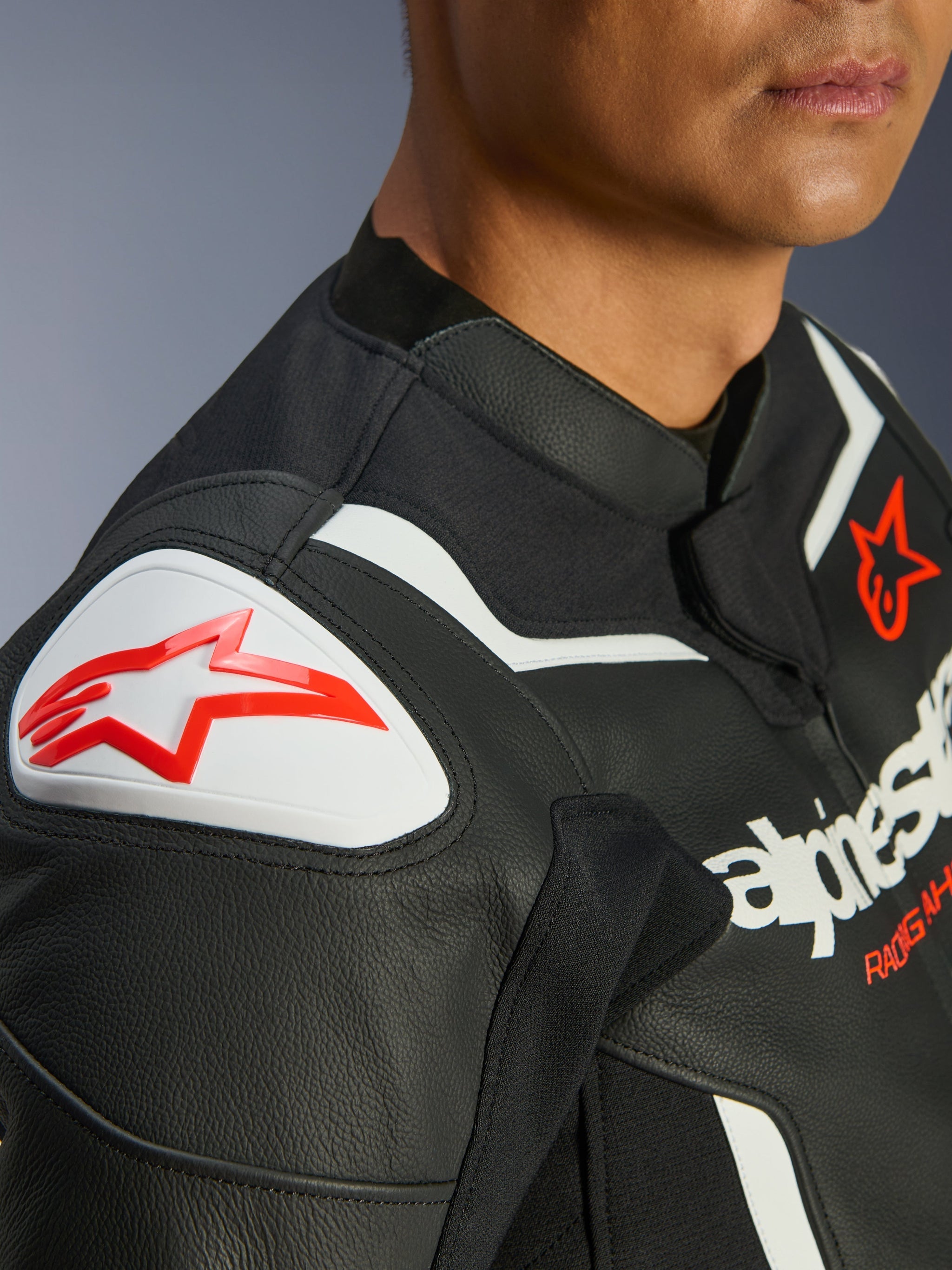 Alpinestars GP Force V2 Leather Jacket, Black and White, close-up of GP Lite Evo DFS shoulder protector with red Alpinestars logo, premium bovine leather multi-panel construction, integrated stretch panels for performance riding