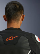 Alpinestars GP Force V2 Leather Jacket, Black and White, close-up view from behind of the neck and shoulders, red Alpinestars logo, premium leather with textile stretch panels, sporty performance design