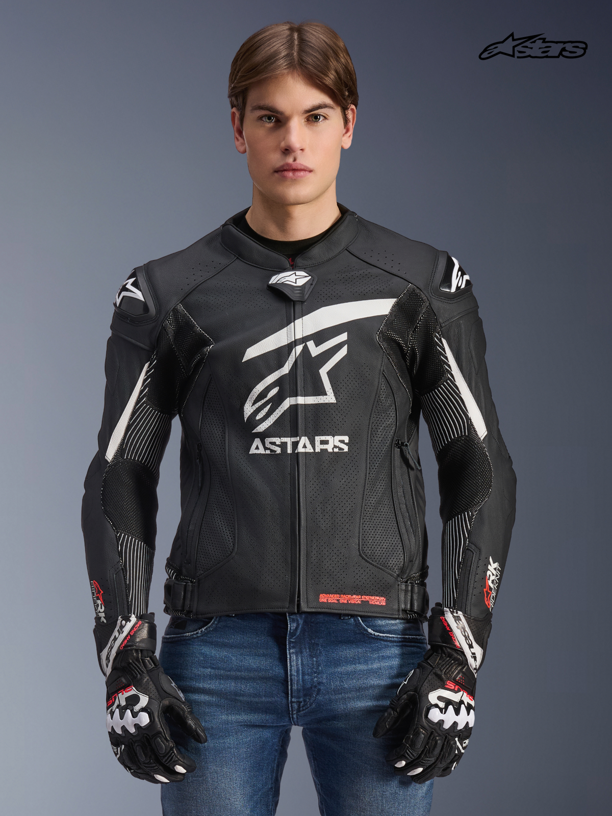 Alpinestars GP Plus R V4 Rideknit Leather Jacket, men's racing motorcycle jacket in black and white, front view on a model wearing matching gloves and jeans, race-derived protection and engineered stretch panels.