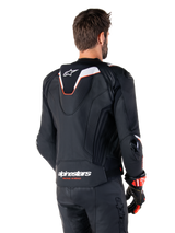 Alpinestars Missile V3 Ignition Leather Jacket, Rear View, Black with White and Red accents, featuring a slim sport Aero-hump and Alpinestars branding, worn with matching leather pants and racing gloves