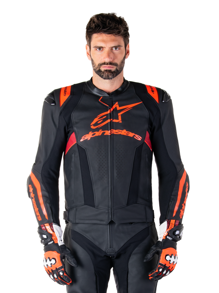Alpinestars Missile V3 Ignition Leather Jacket, Motorcycle Racing Jacket, Black and Red Fluo, worn with matching racing gloves and leather pants, featuring perforated ventilation and prominent Alpinestars branding, professional racing gear
