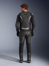 Alpinestars GP Force V2 Air Leather Jacket in Black and White, back view, featuring extensive perforations for airflow, white shoulder accents, and bold branding, worn with black leather motorcycle pants and boots