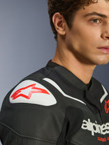 Alpinestars GP Force V2 Air Leather Jacket, Black and White, close-up shot of model wearing the jacket, featuring white GP Lite Evo DFS shoulder slider with red logo and perforated leather detail.