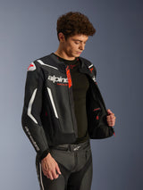 Alpinestars GP Force V2 Air Leather Jacket, Black and White with Red accents, perforated leather construction, unzipped to show interior and black base layer, paired with matching leather pants, professional studio shot for motorcycle road gear