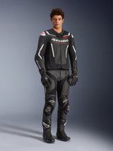 Alpinestars GP Force V2 Air Leather Jacket in Black and White, worn by a male rider with matching black racing pants, gloves, and boots, featuring perforated leather panels, white accents, and red Alpinestars logo on the chest, sport motorcycle riding gear