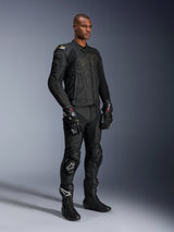 Male model wearing Alpinestars Missile V3 Leather Pants and matching black leather jacket with gold accents, black GP Pro racing gloves, and black racing boots, complete motorcycle racing gear for road use, studio shot.