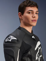 Alpinestars GP Plus V4 Leather Jacket, Black and White, worn by a male model, featuring white Alpinestars logo and DFS shoulder sliders, race-derived leather construction for sport riding