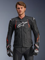 Alpinestars Dusk Airflow Leather Jacket, Black with Red Fluo and White accents, Leather Motorcycle Racing Jacket, featuring extensive perforations for ventilation, white chest logo, and external shoulder sliders, worn by a model with matching racing gloves