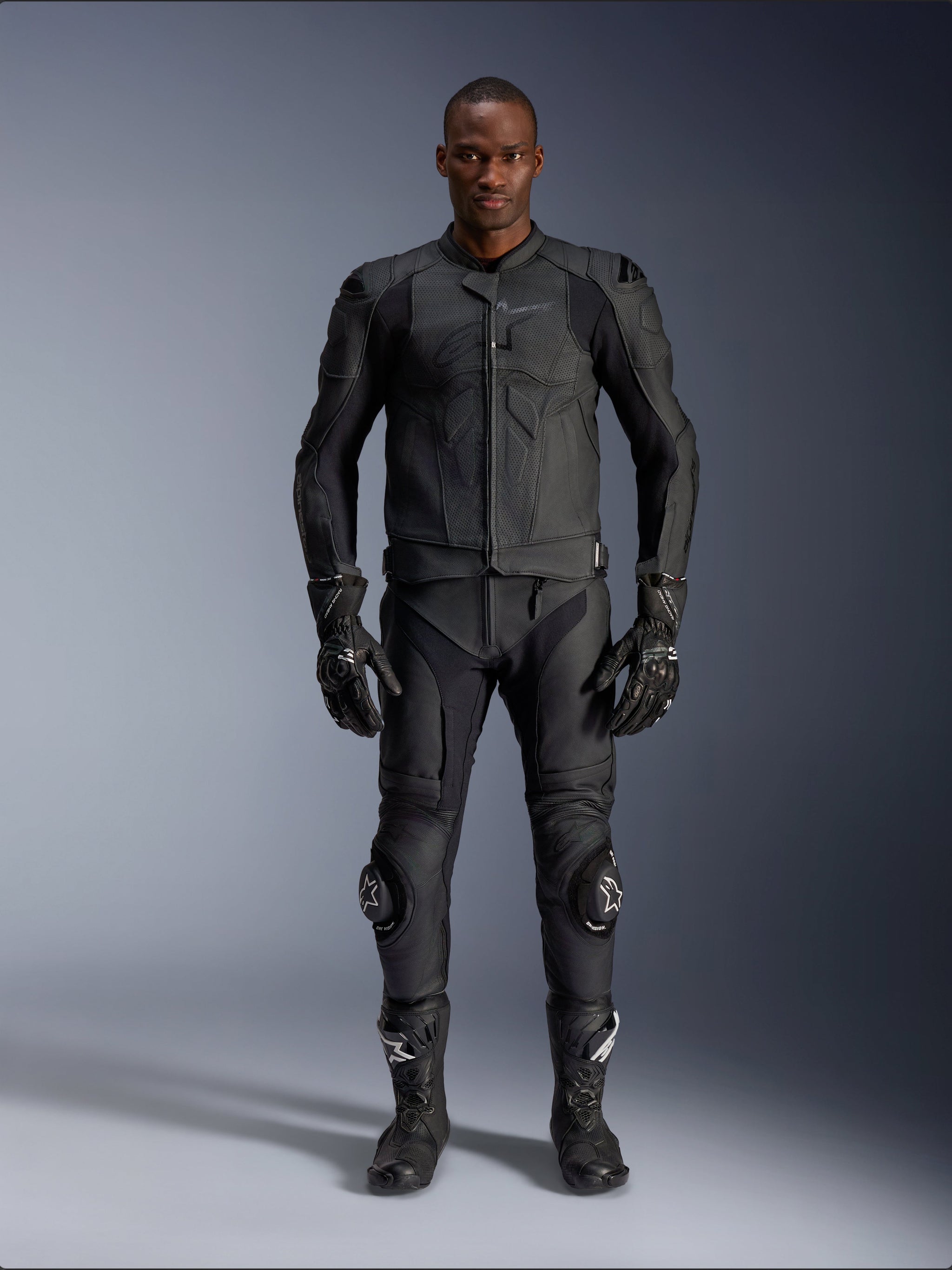 Alpinestars Dusk Airflow Leather Jacket, Black, worn with matching motorcycle pants, gloves, and boots, featuring perforated leather for maximum airflow, ergonomic multi-panel design, and internal armor, professional road and sport riding gear