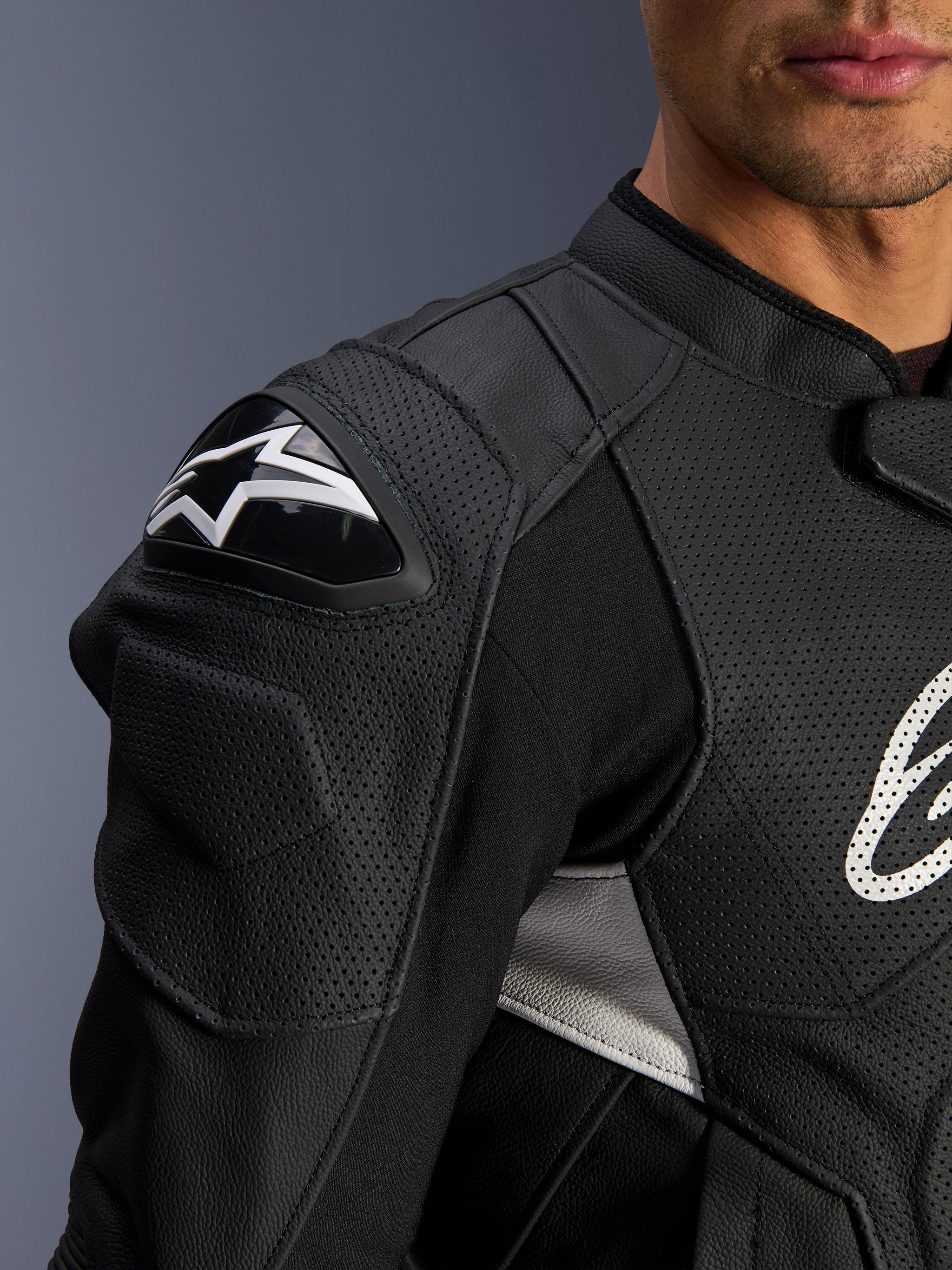 Alpinestars Dusk Airflow Leather Jacket, Black and White, close-up view of the shoulder and chest, featuring perforated leather for ventilation, DFS shoulder protection with white Alpinestars logo, and sporty design.