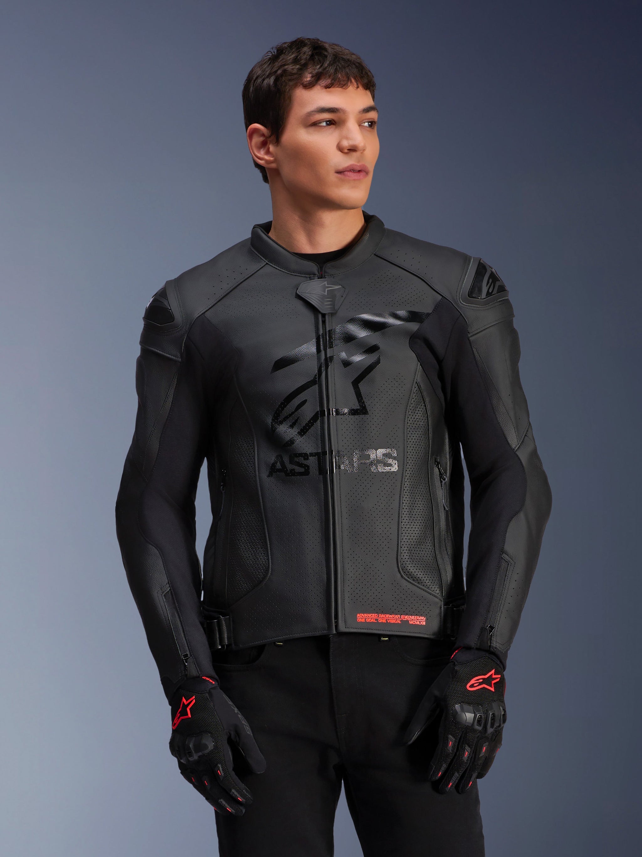 Alpinestars GP Plus R V4 Airflow Leather Jacket, Black, Motorcycle Racing Jacket with perforated leather construction, featuring prominent ASTARS chest branding and DFS shoulder protection, worn with black and red gloves