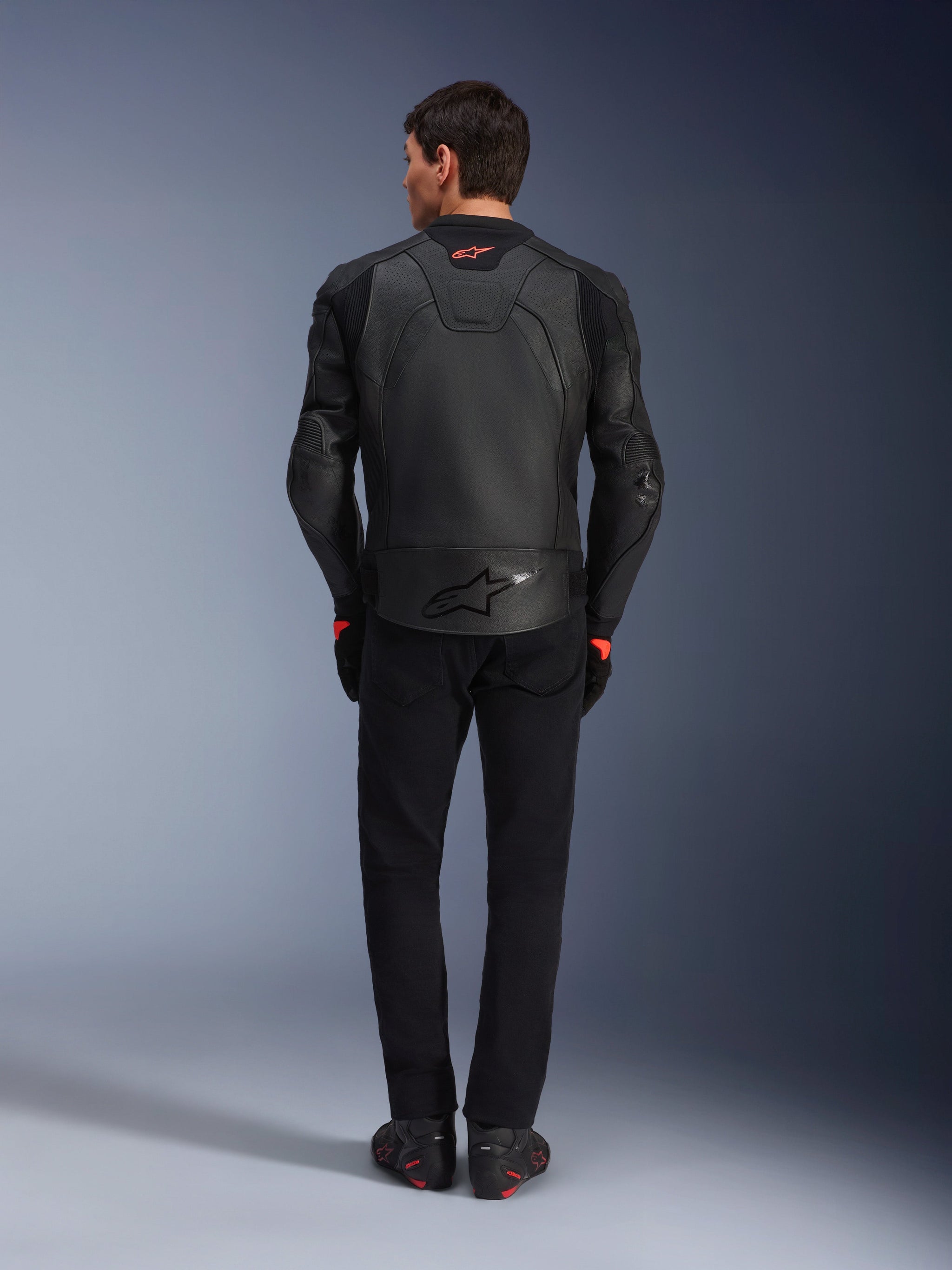 Alpinestars GP Plus R V4 Airflow Leather Jacket, Black, back view of rider wearing complete gear, features perforated leather for ventilation and red logo accents, sleek sport-fit design, paired with black pants and riding boots