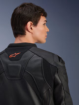 Alpinestars GP Plus R V4 Airflow Leather Jacket, Black, close-up rear view on a model, featuring perforated race-grade leather, technical stretch panels, and a small orange Alpinestars logo on the collar, professional motorcycle riding apparel