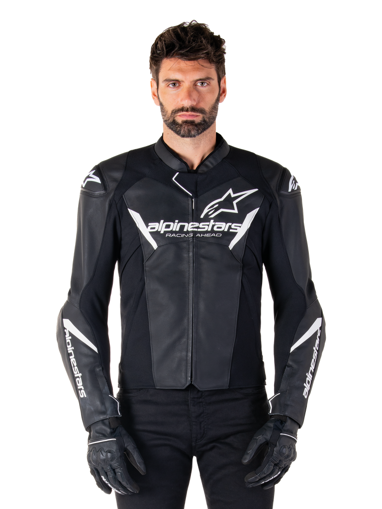 Alpinestars Faster V3 Leather Jacket, Black and White Motorcycle Racing Jacket, featuring bold white logos and 'Racing Ahead' chest text, sleek leather design with angular accents on sleeves, worn with black racing gloves