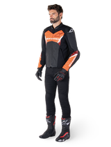 Alpinestars Faster V3 Airflow Leather Jacket, Black and Red Fluo, worn by a male model with black riding pants, gloves, and racing boots, featuring perforated leather and a sport silhouette.