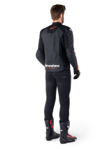 Alpinestars Faster V3 Airflow Leather Jacket, Black and Red Fluo, seen from behind on a rider, featuring perforated leather panels and bold branding, worn with black pants and motorcycle boots, sport riding attire.