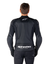 Alpinestars Faster V3 Airflow Leather Jacket, Black and White, rear view of a rider showing the perforated leather back panel for ventilation, white Alpinestars logo on upper back and 'RACING AHEAD' branding on lower back, sport-fit motorcycle gear.