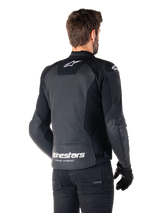 Alpinestars Faster V3 Airflow Leather Jacket, Black and White, rear view on a model, featuring perforated leather back for ventilation, white Astars logos on the upper back and lower waist with 'Racing Ahead' text, sporty design with stretch panels for motorcycling.