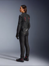 Woman Stella Dusk Leather Jacket, Black Diva Pink White, rear three-quarter view on a rider, worn with black riding pants and black boots, featuring sleek leather construction with pink accents and a white Alpinestars logo on the lower back.