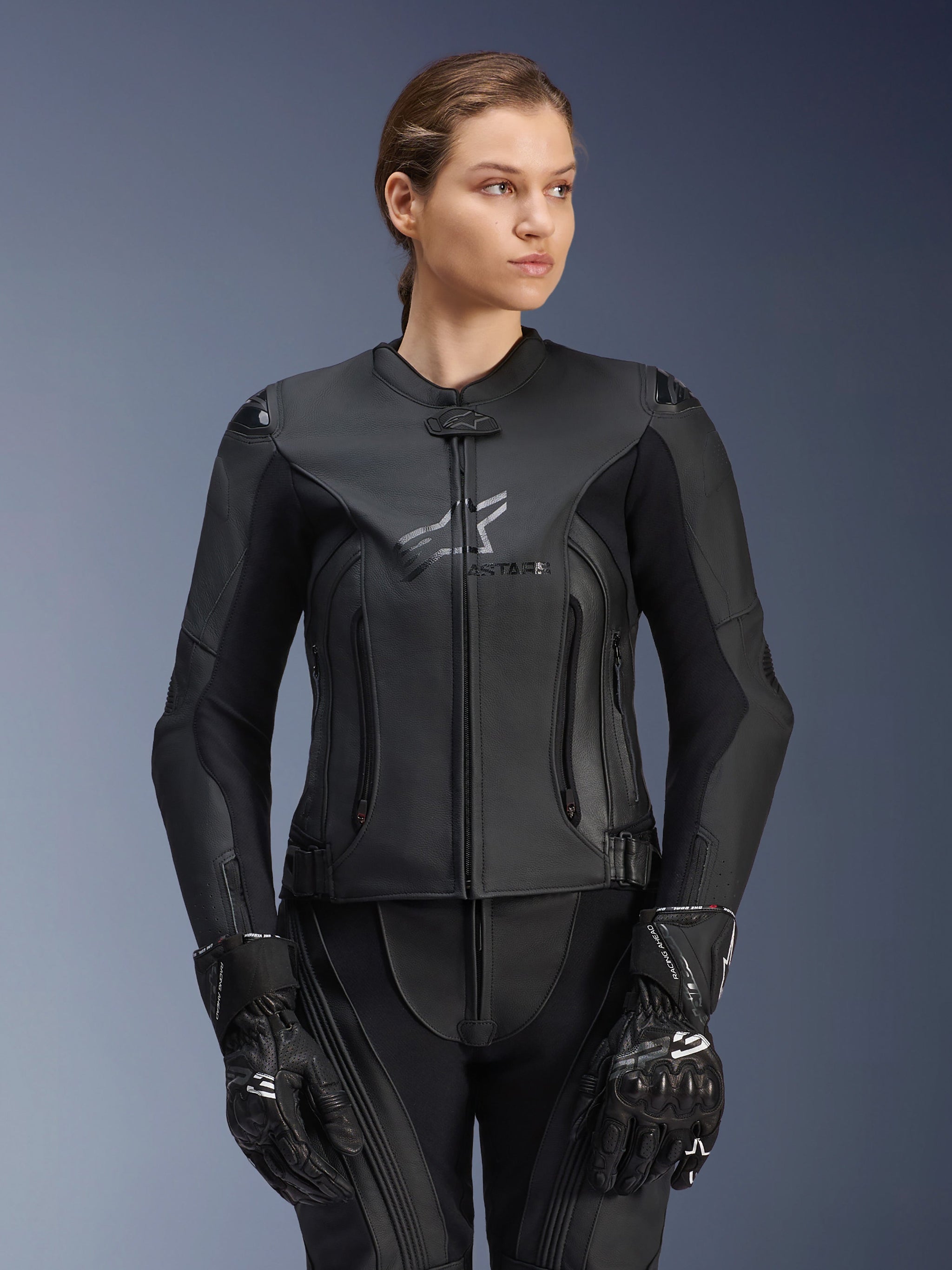 Alpinestars Stella GP Plus V4 Leather Jacket, Black, Women's Motorcycle Racing Jacket, premium leather construction with protective padding, sleek design with subtle logo, worn by a female model with matching black gear