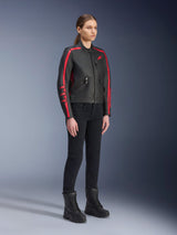Female model wearing the Alpinestars Stella Dyno Leather Jacket in Black Haute Red, paired with black pants and boots, heritage-style leather motorcycle jacket with red stripes on the arms and red logo, urban and road riding gear for women