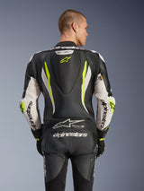 Alpinestars GP Tech V5 One Piece Leather Suit, back view on model, Black White and Yellow Fluo, featuring aerodynamic hump, large Alpinestars branding on arms and seat, accordion stretch panels, and Tech-Air Ready logo