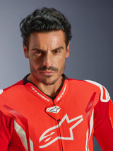Alpinestars GP Tech V5 One Piece Leather Suit, Motorcycle Racing Suit, Red Fluo Bright Red and White, close-up portrait of a rider, perforated leather chest with white Alpinestars logo, high-performance racing collar and aerodynamic design.