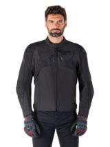 Alpinestars T-Jaws V4 Waterproof Jacket, Black Motorcycle Sport Jacket, worn by a man with black gloves featuring red accents, reinforced shoulders and arms, sleek design with subtle chest logo, textile all-weather riding gear