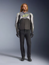 Alpinestars T-Jaws V4 Waterproof Jacket in Black Ice Gray Dark Gray with neon yellow accents, worn by a male model, featuring a sporty silhouette, technical textile construction, and prominent chest logo, styled with black riding pants and gloves