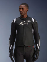 Alpinestars T-SP 1 V2 Waterproof Jacket, Sport Textile Motorcycle Jacket, Black and White with subtle red details, worn by a male model with matching gloves and pants, featuring white Alpinestars logo on chest, T-SP-1 branding, and protective silhouette for road riding