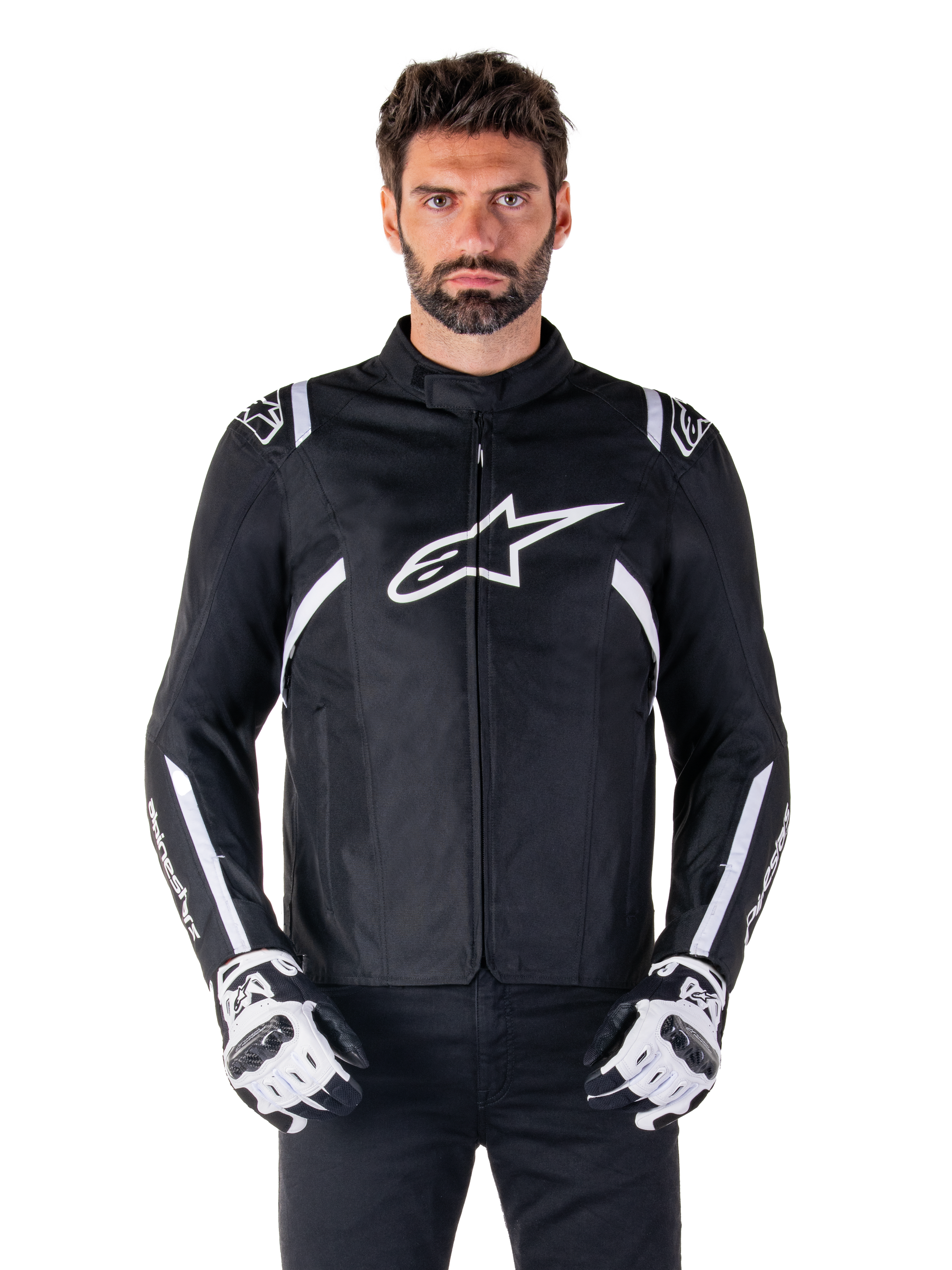 Alpinestars T-SPS V2 Waterproof Jacket in Black and White, front view on model, waterproof textile motorcycle jacket featuring white shoulder and arm stripes, large white Alpinestars logo on chest, worn with protective motorcycle gloves, sleek sport-inspired silhouette
