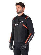 Alpinestars T-SPS V2 Waterproof Jacket, Black White and Red Fluo, worn by a male model with black gloves and pants, featuring a white Alpinestars logo on the chest and fluorescent red accents on the shoulders and sleeves, sporty textile design