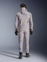 Alpinestars Aeroshell Waterproof Jacket in Mid Gray Yellow Fluo, full back view, worn with matching gray pants, black gloves, and black riding shoes. Features a hooded softshell design with yellow fluo 'ASTARS' branding and accents, engineered for modern motorcycle road performance.