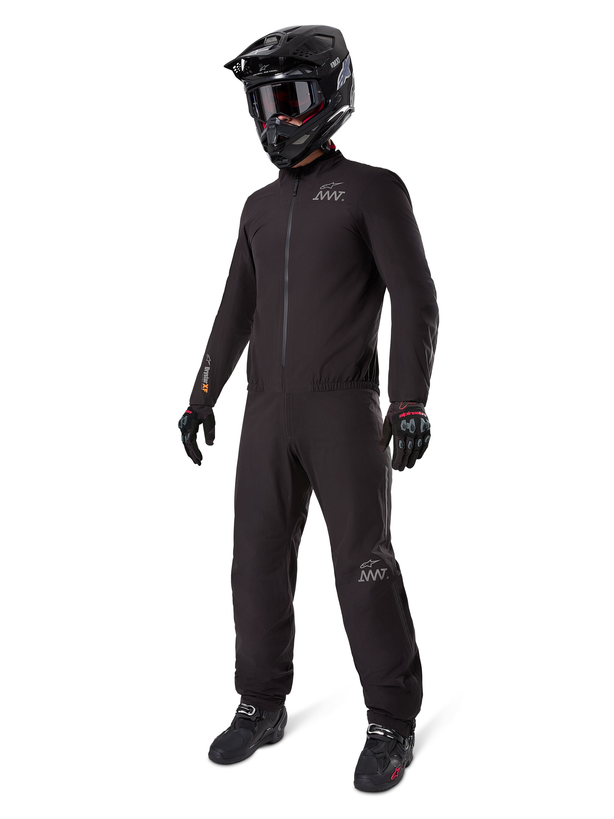 Alpinestars AMT-8 Stretch Drystar® XF Liner, black waterproof motorcycle suit, worn with black helmet, goggles, and gloves, featuring AMT and Drystar XF branding, functional adventure gear for all-weather protection.
