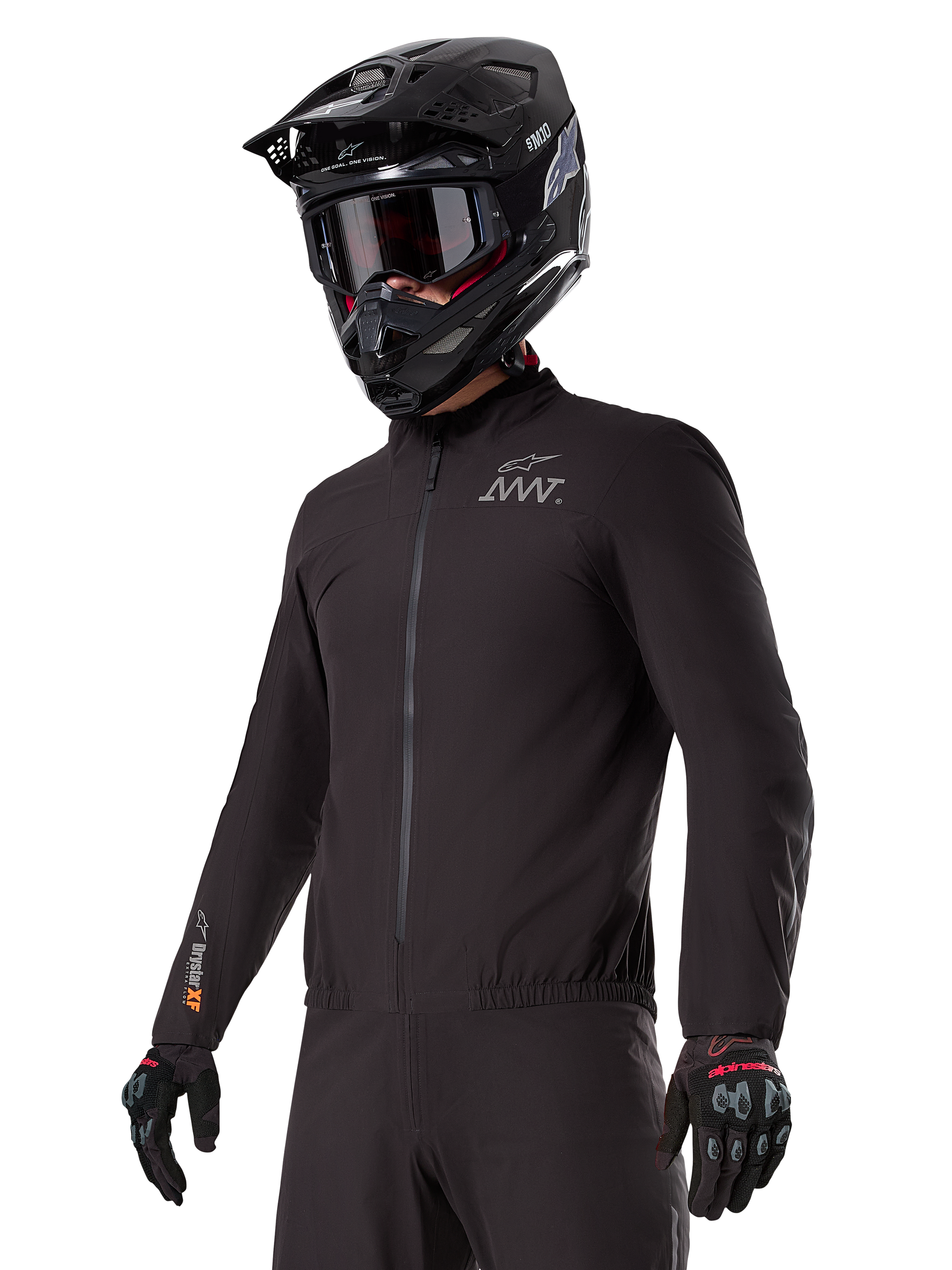Rider wearing the Alpinestars AMT-8 Stretch Drystar® XF Liner, black windproof and waterproof stretch jacket, featuring AMT logo on the chest and Drystar XF branding on the sleeve, paired with a black adventure helmet and protective gloves.