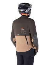 Alpinestars AMT-8 Stretch Drystar® XF Jacket, Adventure Motorcycle Jacket, Dark Brown and Dark Khaki, rear view showing AMT Alpinestars Motion Technology branding, two-tone textile design with back ventilation zippers and shingle-style exhaust, worn with black helmet and riding pants