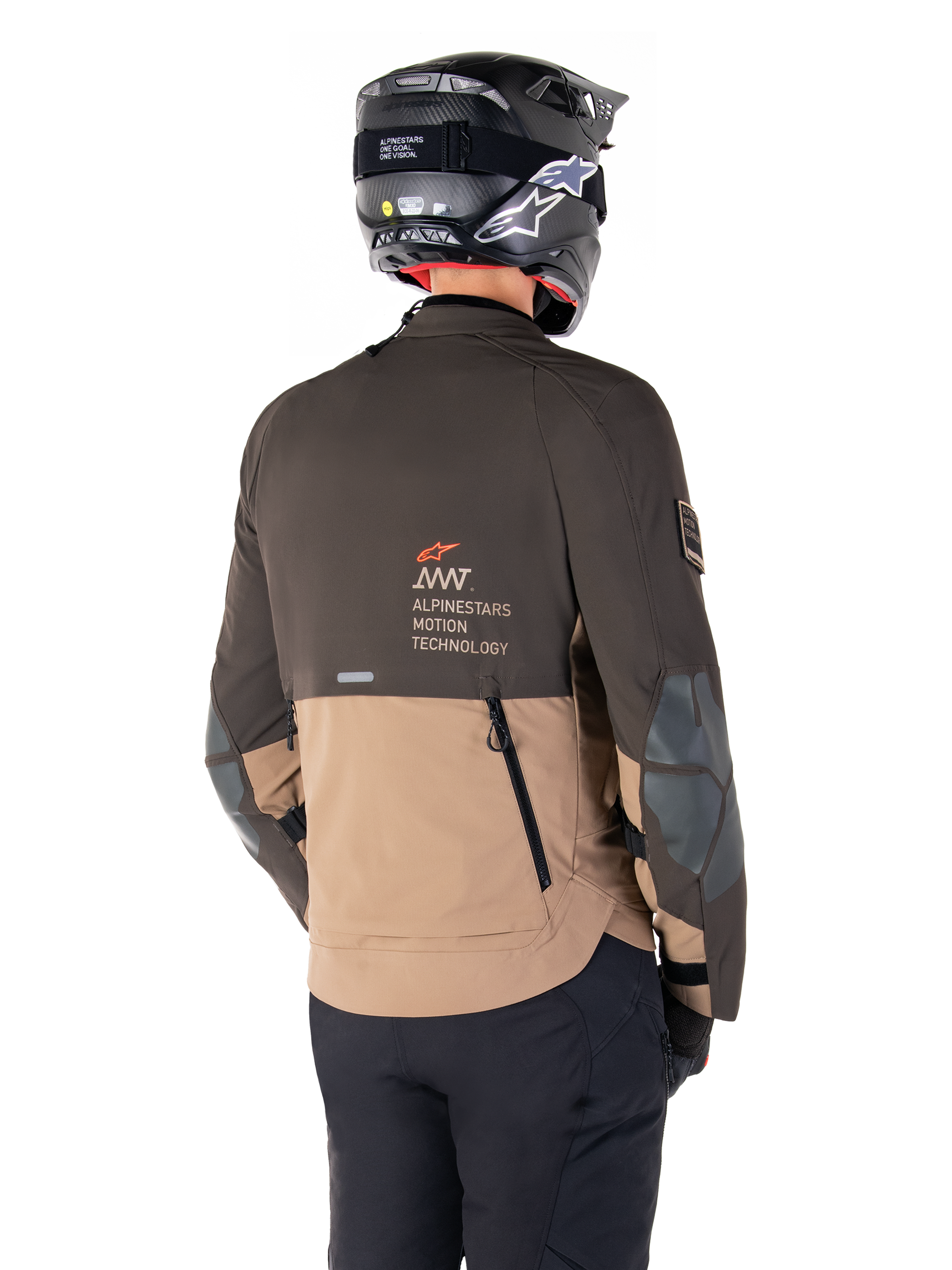 Alpinestars AMT-8 Stretch Drystar® XF Jacket, Adventure Motorcycle Jacket, Dark Brown and Dark Khaki, rear view showing AMT Alpinestars Motion Technology branding, two-tone textile design with back ventilation zippers and shingle-style exhaust, worn with black helmet and riding pants