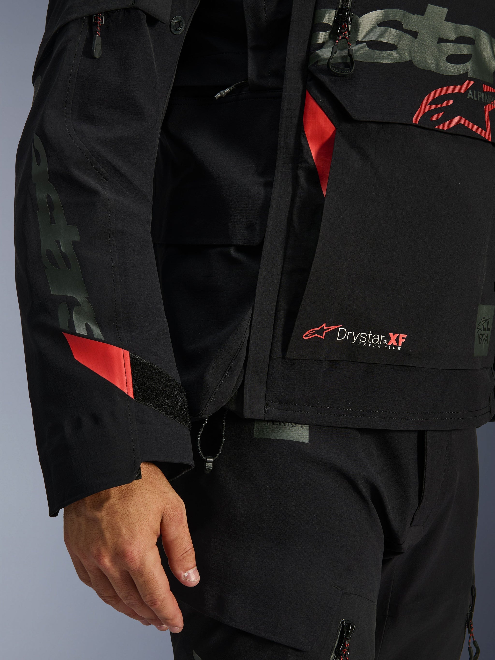 Alpinestars Halo Pro Drystar® XF Laminated Jacket, Motorcycle Jacket, Black with red accents, close-up featuring Drystar® XF branding, technical laminated shell texture, and adjustable sleeve details for adventure riding