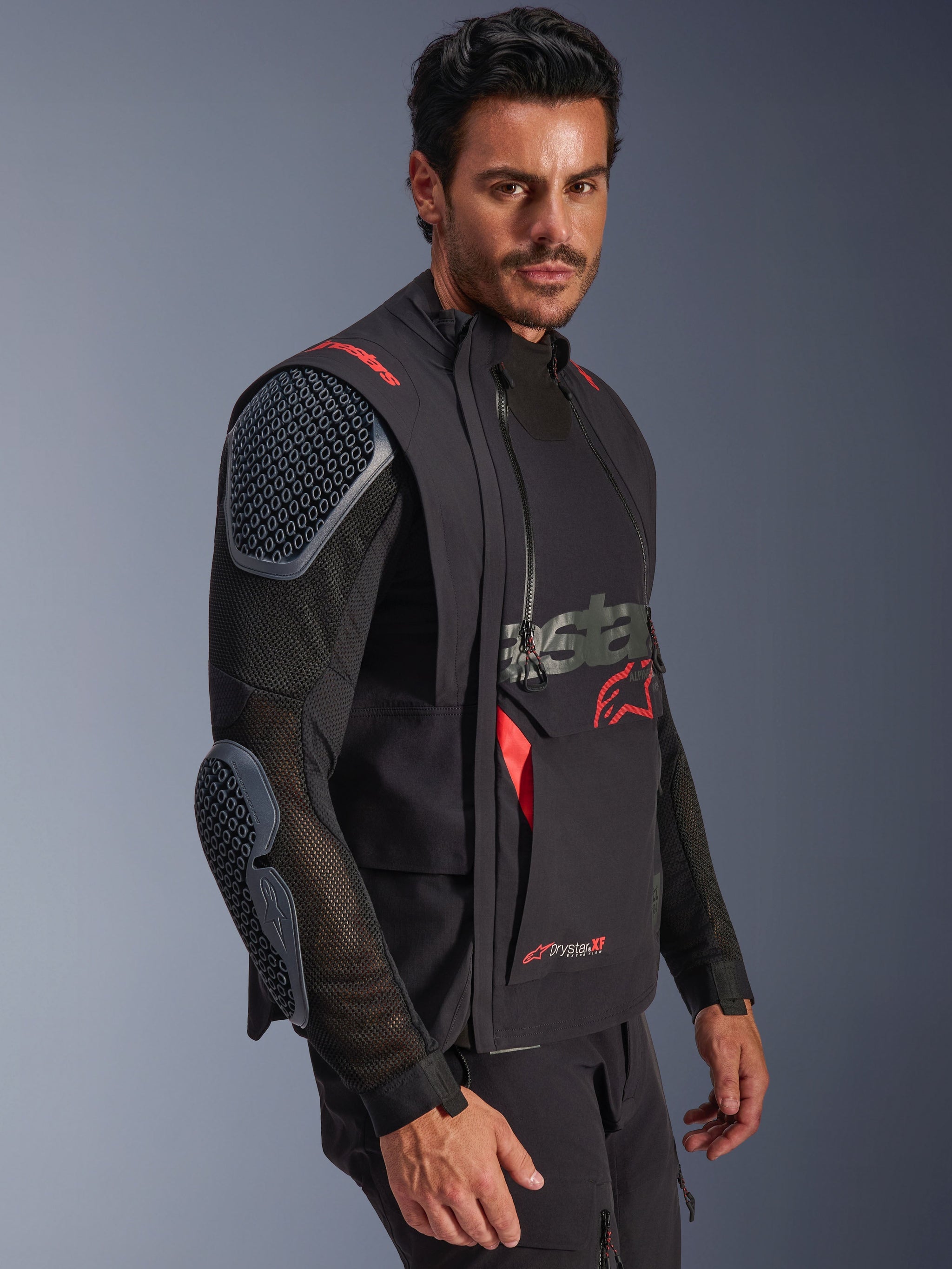 Alpinestars Halo Pro Drystar® XF Laminated Jacket, Black and Dark Shadow, adventure motorcycle jacket worn by model, modular configuration featuring mesh sleeves with integrated shoulder and elbow armor, red logo accents and technical waterproof zippers.