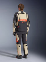Alpinestars Halo Pro Drystar® XF Laminated Jacket, Mastic Black, back view, adventure motorcycle jacket with large orange 'astars' branding across the rear, worn with matching technical pants and boots, modular design for versatile terrain