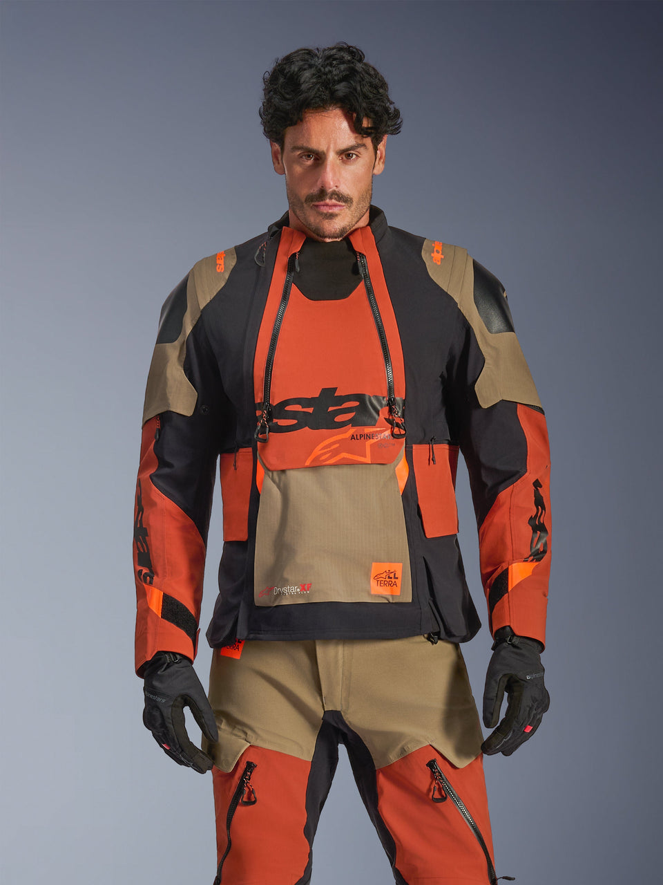 Alpinestars Harok Pro Drystar XF Laminated Jacket, adventure motorcycle touring jacket in walnut rust, black, and tan, worn by a model in a front view featuring waterproof laminated construction and modular ventilation