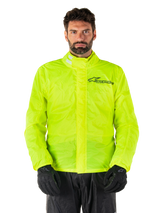 Alpinestars Hurricane Rain V2 Jacket, Motorcycle Rain Jacket, Yellow Fluo, worn by a model with black pants and gloves, high collar with reflective tabs, front storm flap with Alpinestars logo, high-visibility waterproof gear