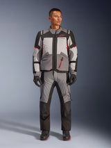 Alpinestars Andes V4 Drystar® Jacket, Motorcycle Adventure Jacket, Dark Gray, Ice Gray, Black, and Bright Red, worn with matching textile riding pants and gloves, featuring a technical multi-panel design with a red Alpinestars logo, adventure-touring gear.