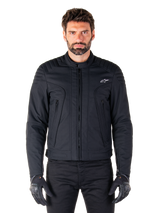 Alpinestars Clayton WR Jacket, Black Motorcycle Jacket, worn by model, featuring quilted shoulder details and technical graphics, central Vislon zipper, vertical zippered pockets, small white logo on chest, urban riding gear for road use