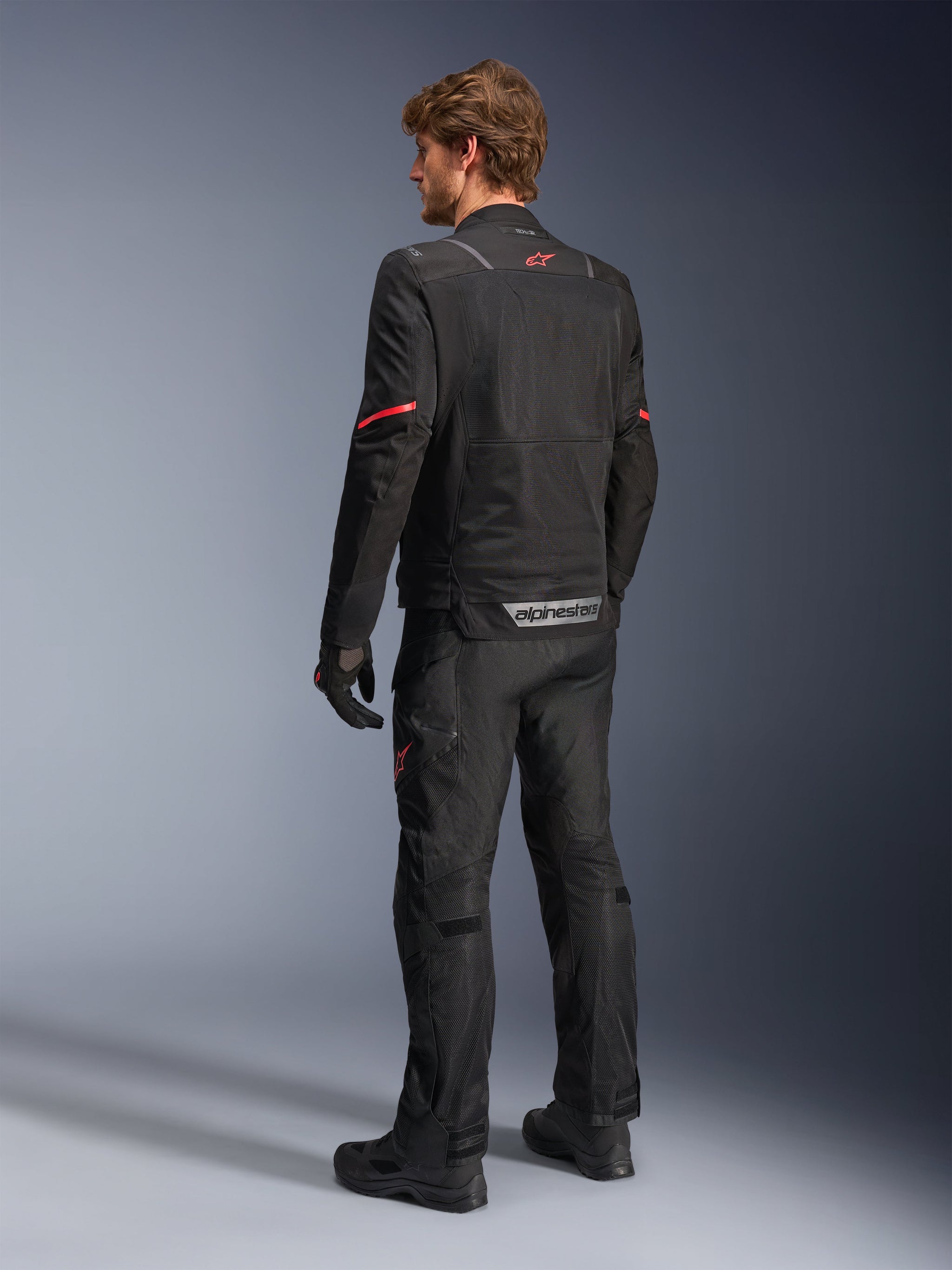 Alpinestars ST-2 Air Jacket, black adventure touring motorcycle jacket for men, mesh panels, red star logo, rear view.