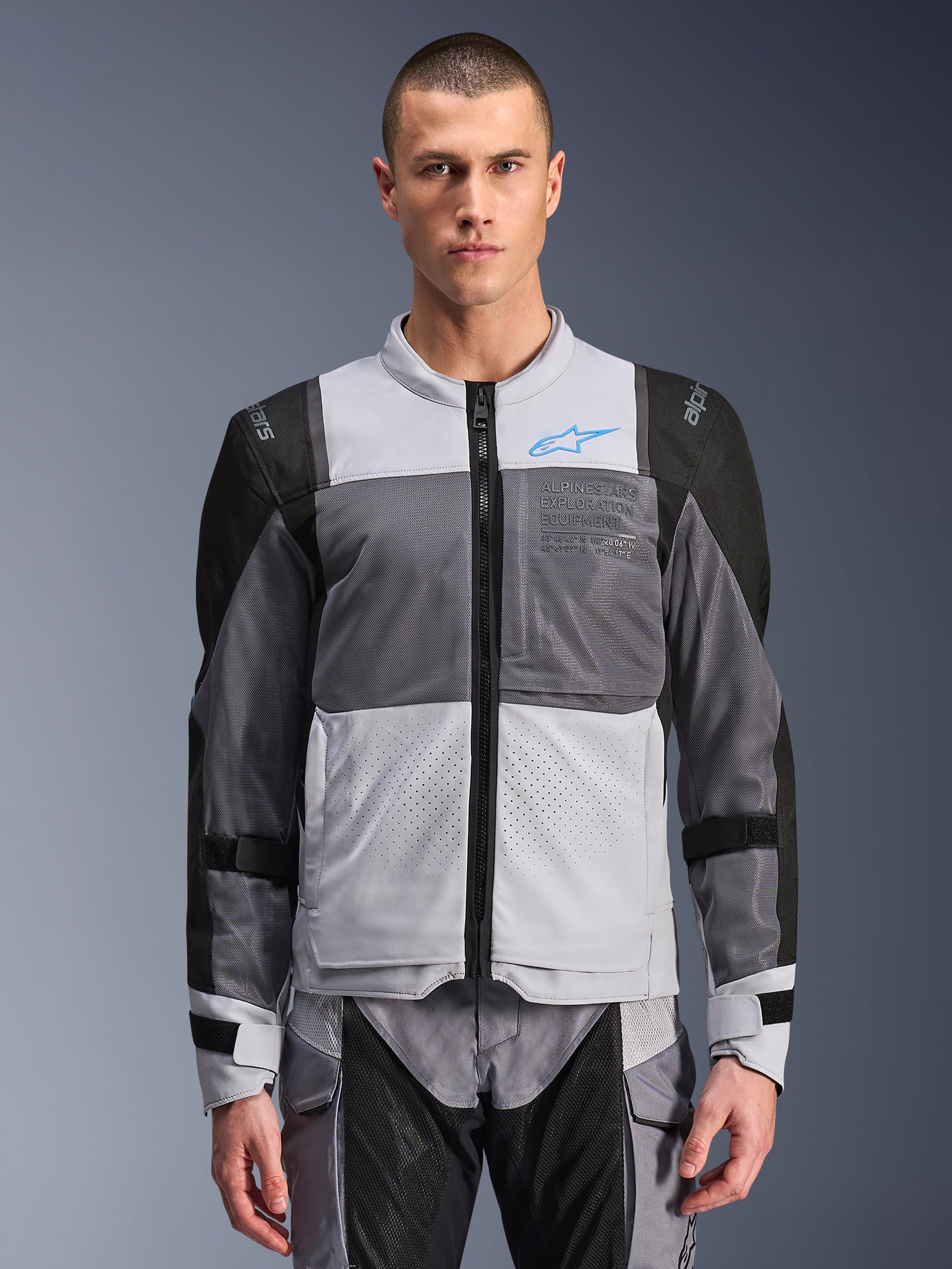 Alpinestars ST-2 Air Jacket, Men's Motorcycle Jacket, Ice Gray and Dark Gray with Black accents, wide mesh ventilation panels, laser-perforated front, blue Alpinestars logo, front zipper, worn by a model with matching riding pants