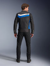Alpinestars T-Dyno WR Jacket, textile motorcycle jacket, Black Blue Ecru colorway, full back view on model, featuring a blue and off-white chevron stripe with Alpinestars logo, paired with black pants and boots, vintage-inspired urban riding gear