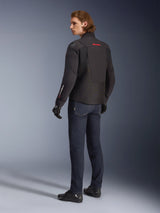 Alpinestars SMX Waterproof Jacket, Black motorcycle jacket with red and white accents, male rider shown from the back wearing dark blue riding jeans and black gloves, featuring external shoulder protection and elongated rear hem for road riding coverage